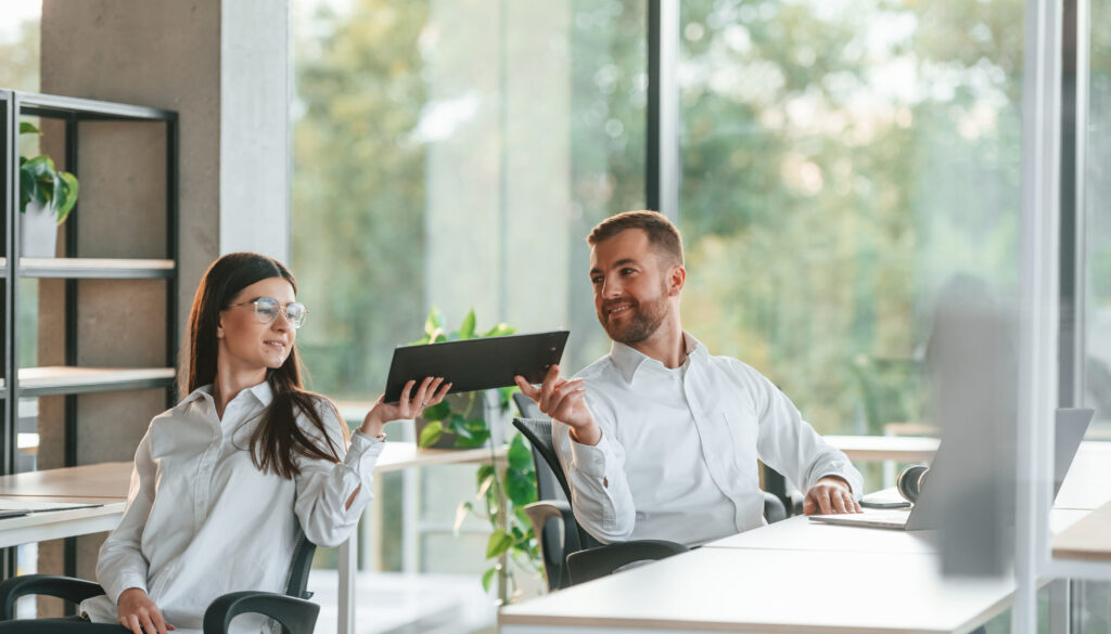 Friendly talking. Man and woman are working in the modern office together
