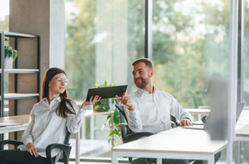 Friendly talking. Man and woman are working in the modern office together