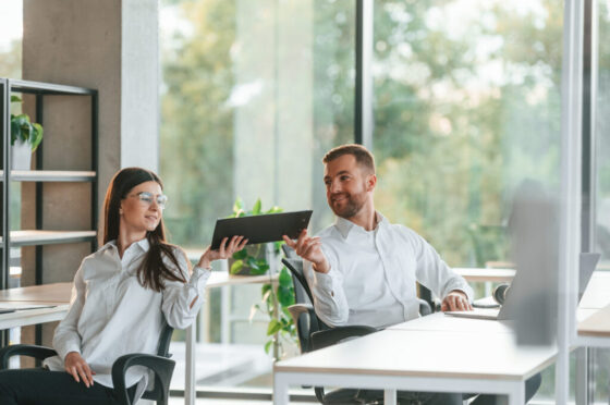 Friendly talking. Man and woman are working in the modern office together