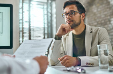 Young pensive man having a job interview in the office.